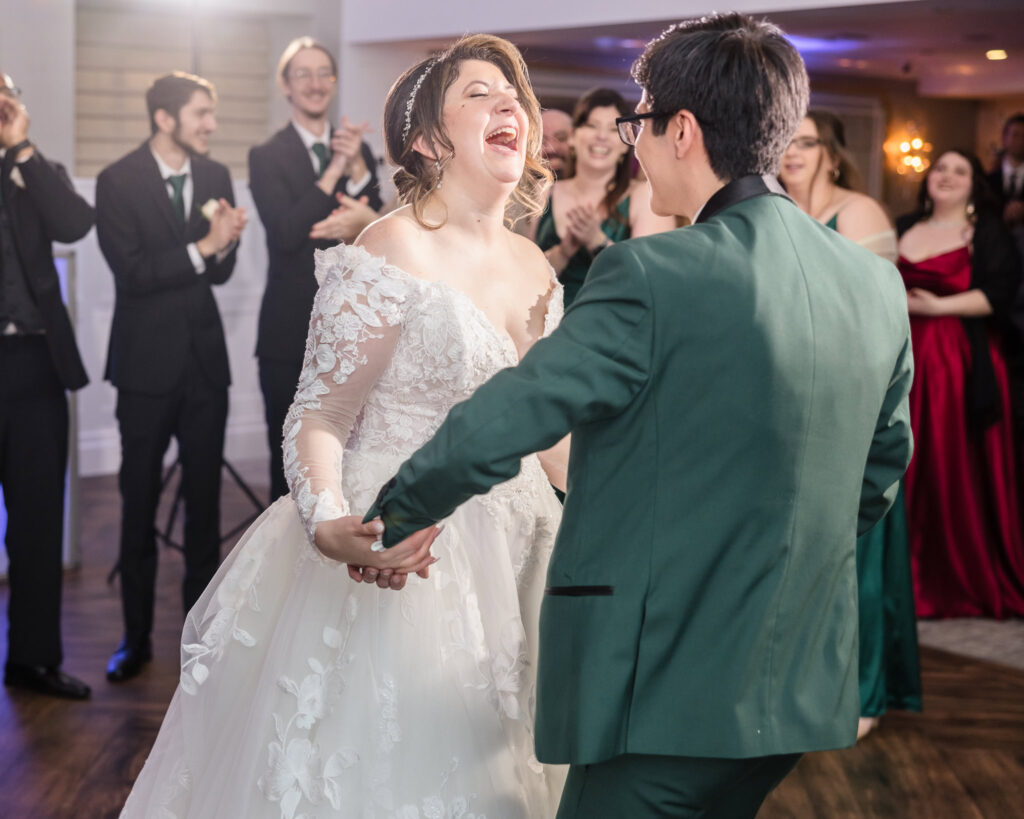 Bride laughing while she is dancing with the groom at Water's Edge.