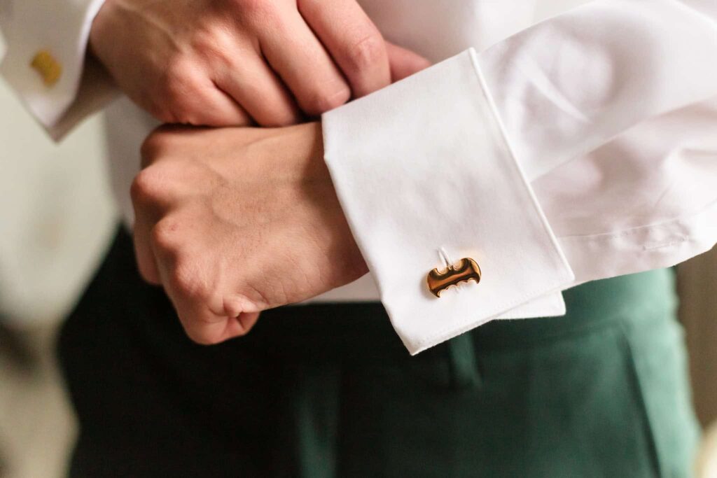 Groom putting on his cufflinks.