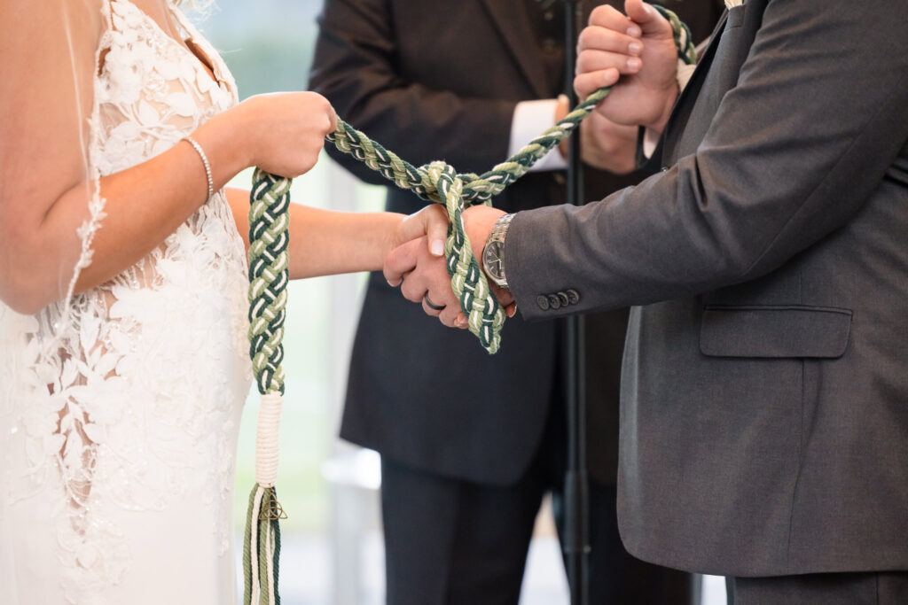 Bride and groom tying their hands during wedding ceremony at Stonebridge Country Club.