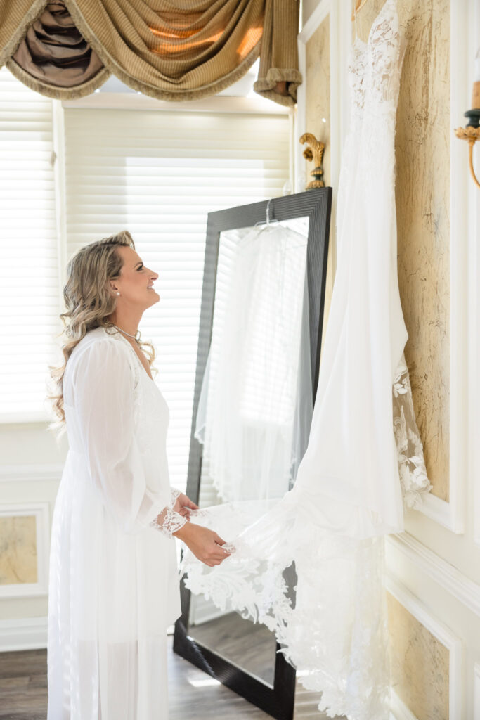 Bride holding looking at her dress in the bridal suite at Stonebridge Country Club. 