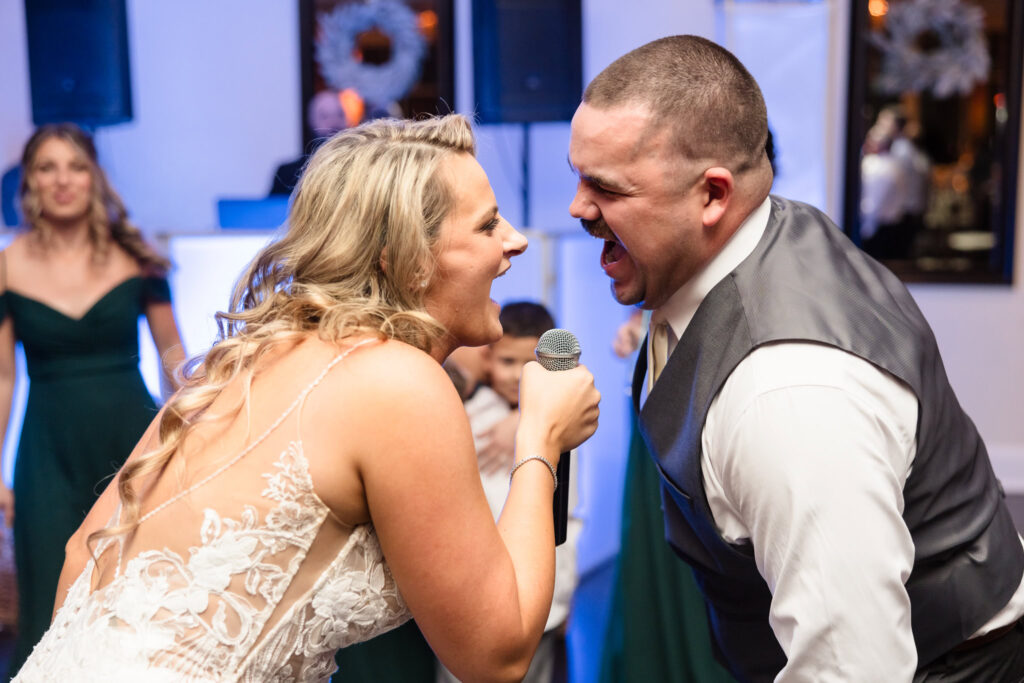 Bride and groom singing together into the same microphone during Stonebridge Country Club wedding reception. 