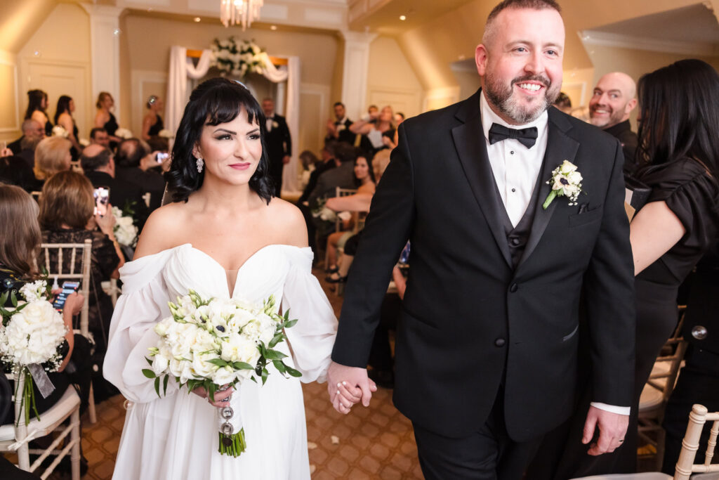 Bride and groom walking down the aisle after wedding ceremony at Inn at New Hyde Park.