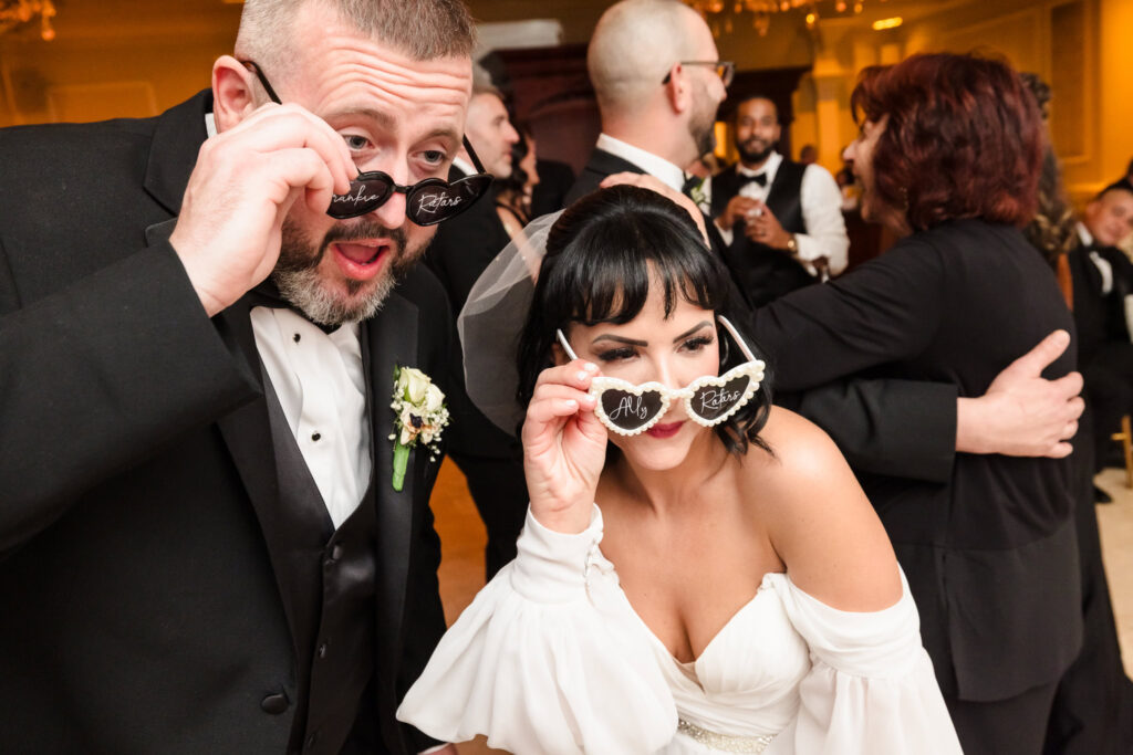 Bride and groom looking over sunglasses at The Inn at New Hyde Park.