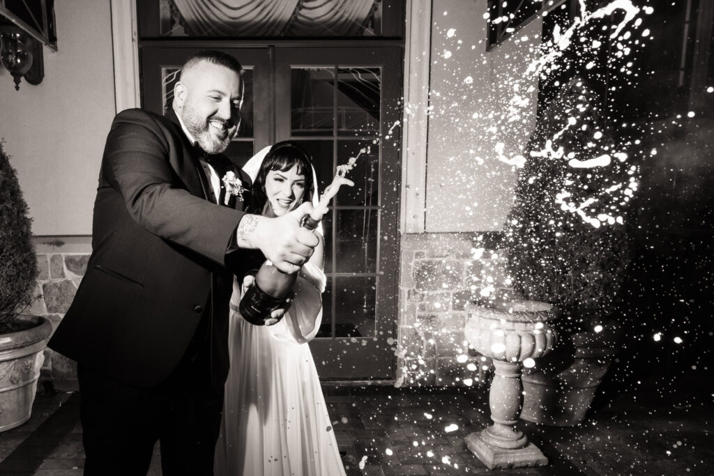 Bride and groom spraying champagne and laughing at The Inn at New Hyde Park
