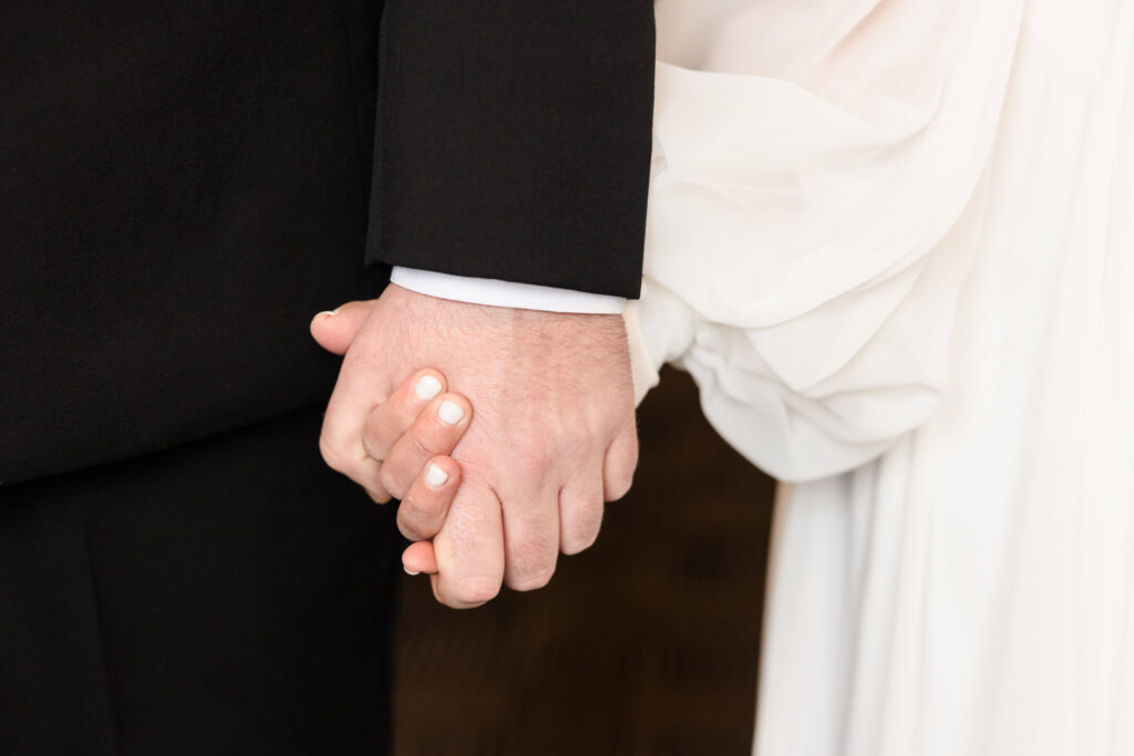 Hands of bride and groom holding hands at Inn at Great Neck.