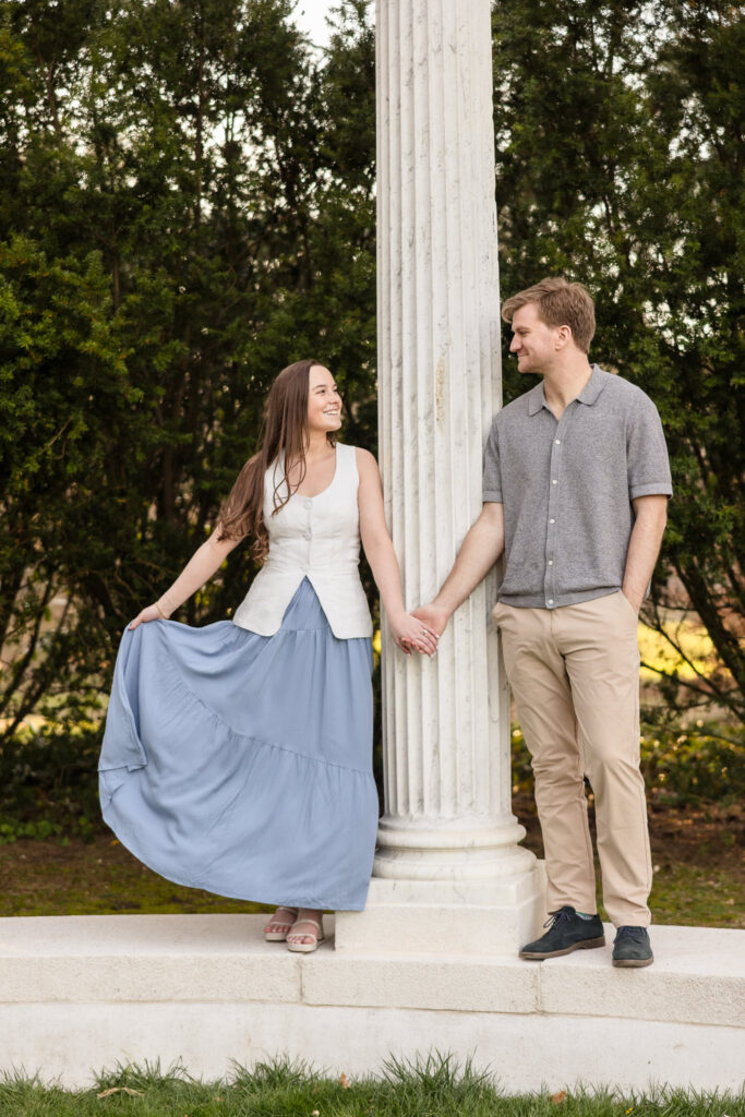 Bride twirling between columns as the groom watches.