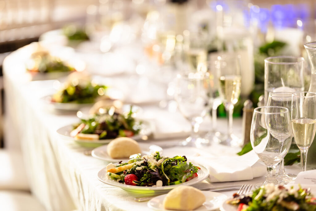 Reception table set with fresh spring salads, champagne flutes, and soft candlelight at The Briarcliff Manor.