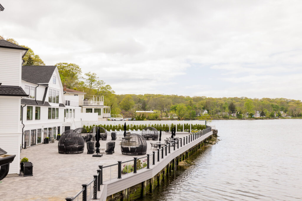 Waterfront terrace at Water’s Edge Centerport with lounge seating and views overlooking Mill Pond.