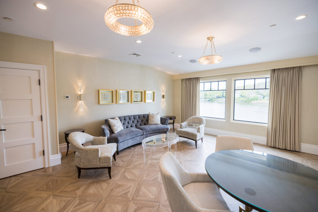 Spacious wedding suite at Water’s Edge Centerport featuring soft seating, chandeliers, and warm natural light.