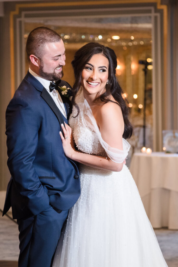 Bride and groom share a joyful embrace during their wedding reception at Water’s Edge Centerport.