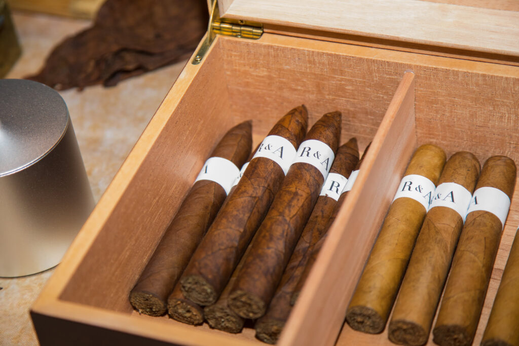 Close-up of hand-rolled cigars in a wooden box at Water’s Edge Centerport wedding.