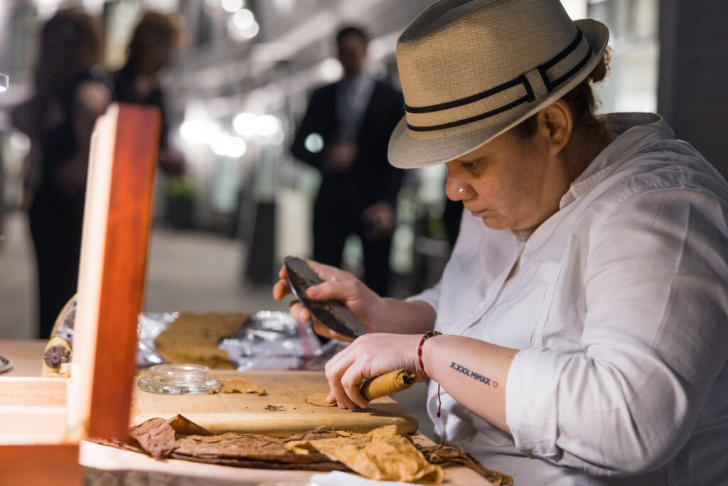 Cigar roller crafts a cigar for guests during the evening celebration at Water’s Edge Centerport.