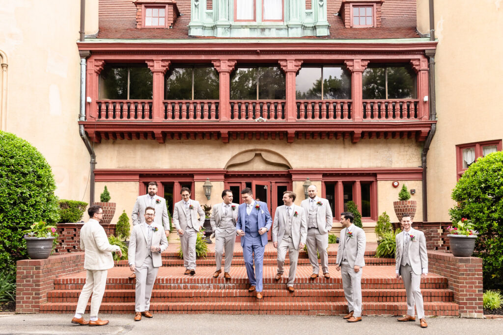 Wedding party walking down the estate steps with joyful energy and elegant style