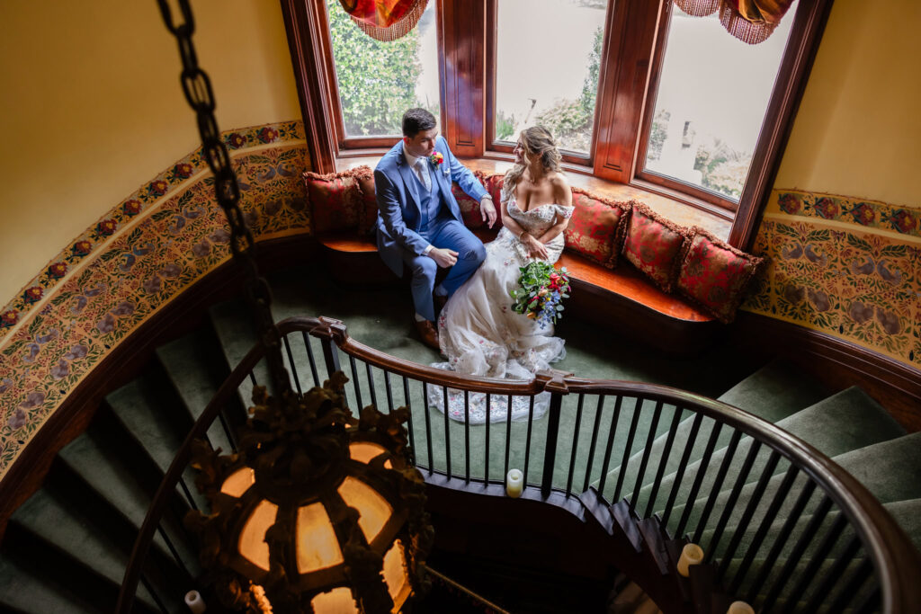 Couple seated together at the foot of the spiral staircase inside Coindre Hall