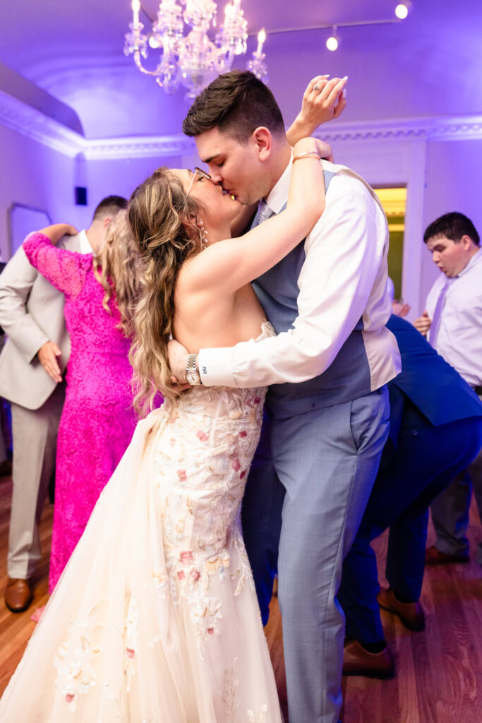 Bride and groom dancing with joy during vibrant wedding reception