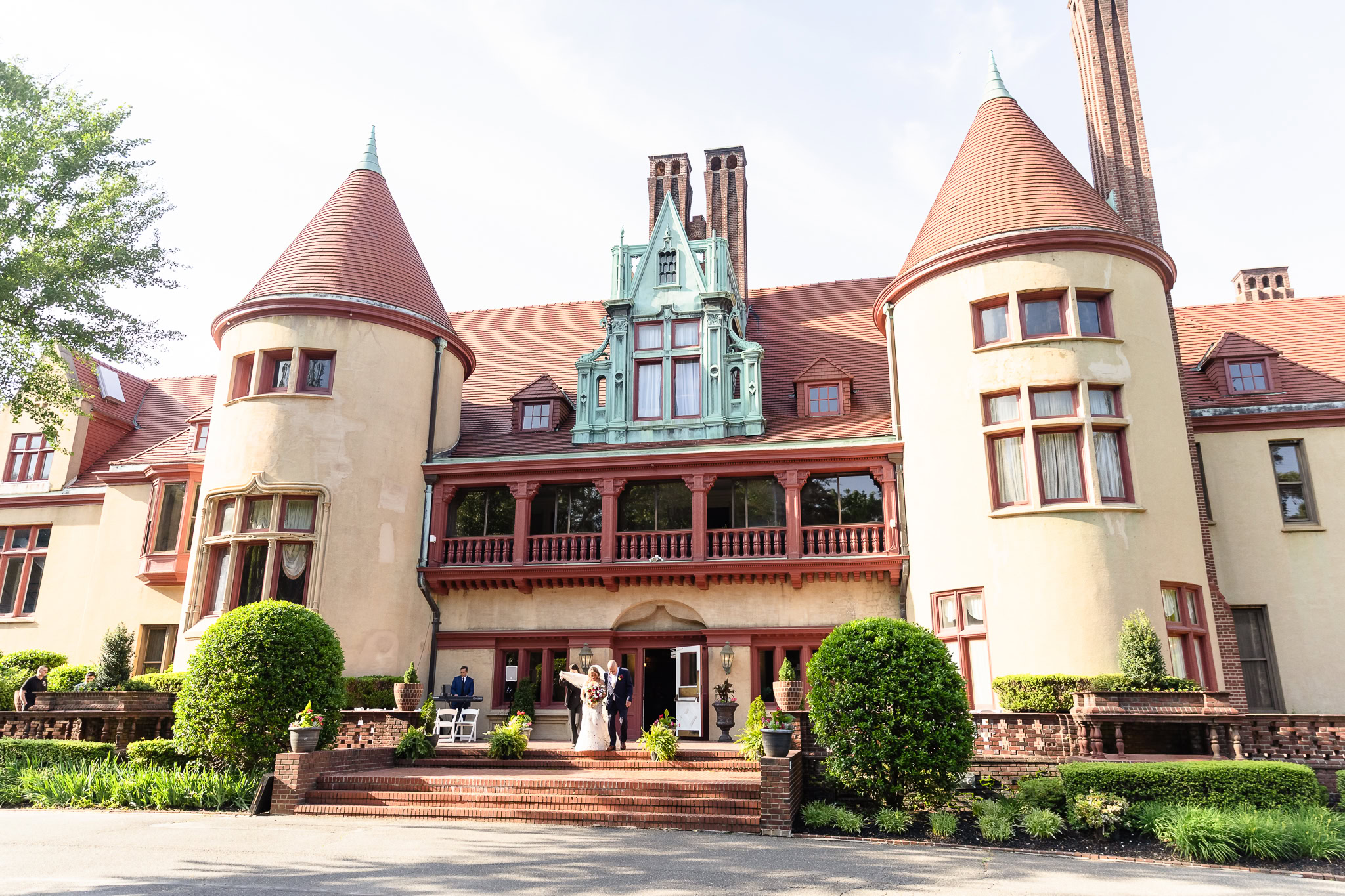 Golden-hour view of Coindre Hall’s castle-like exterior, showcasing its grand architecture and lush landscaping.