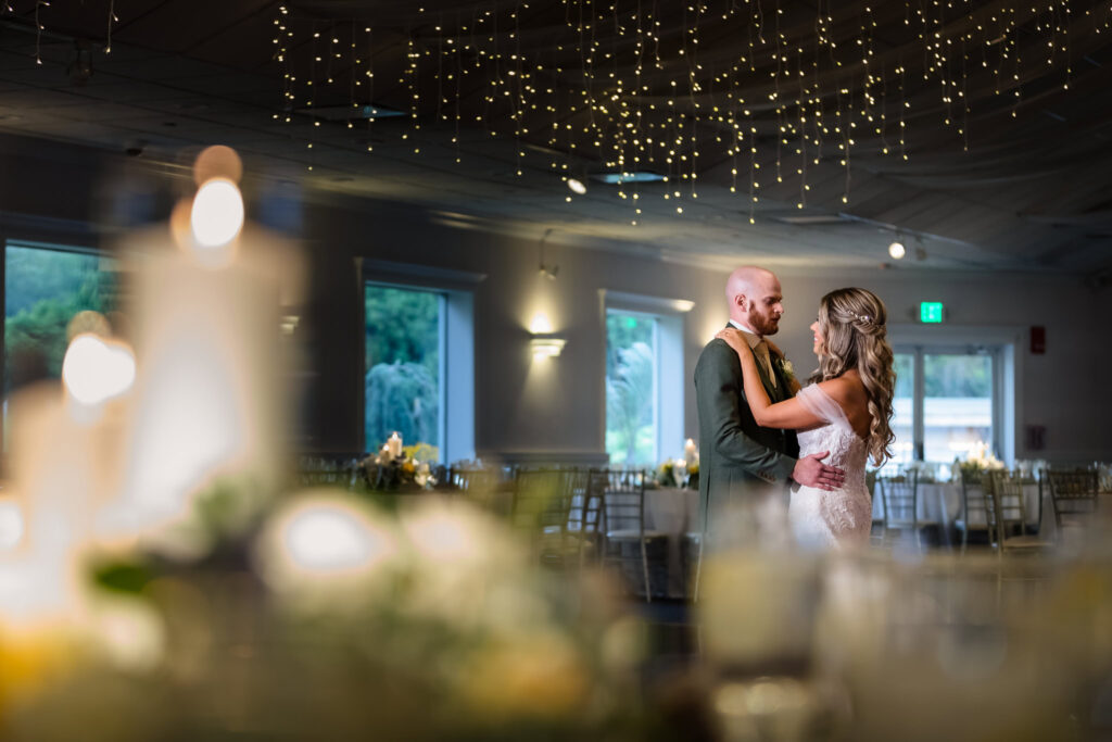 Bride and groom share an intimate dance beneath fairy lights in Flowerfield’s Grand Ballroom, surrounded by candlelight and elegant reception décor.