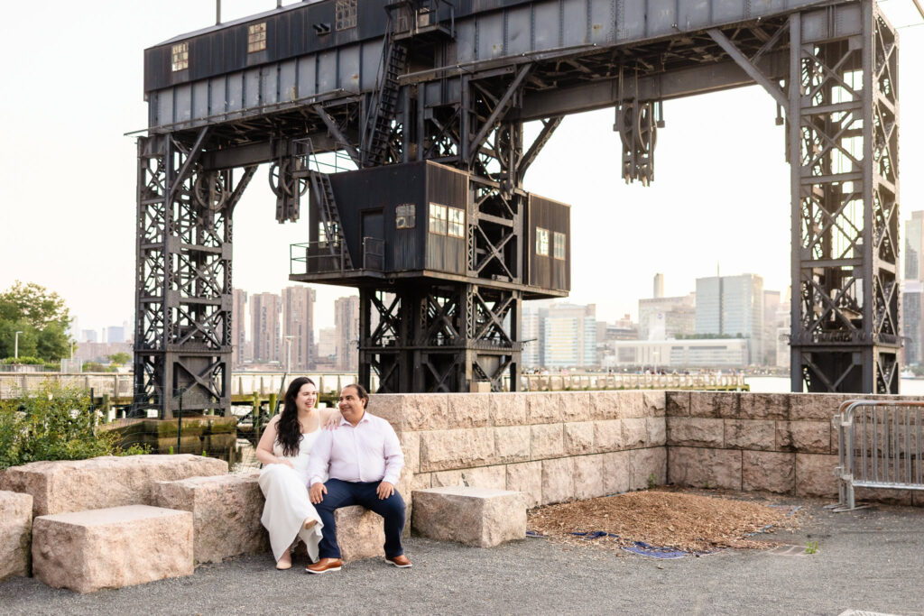 Couple seated on stone steps beneath the Gantry cranes, sharing a peaceful moment together.