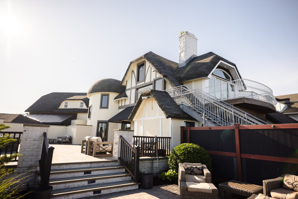 Exterior view of Land’s End Waterfront Catering, showcasing its coastal architecture, terrace, and guest lounge spaces on a sunny day.
