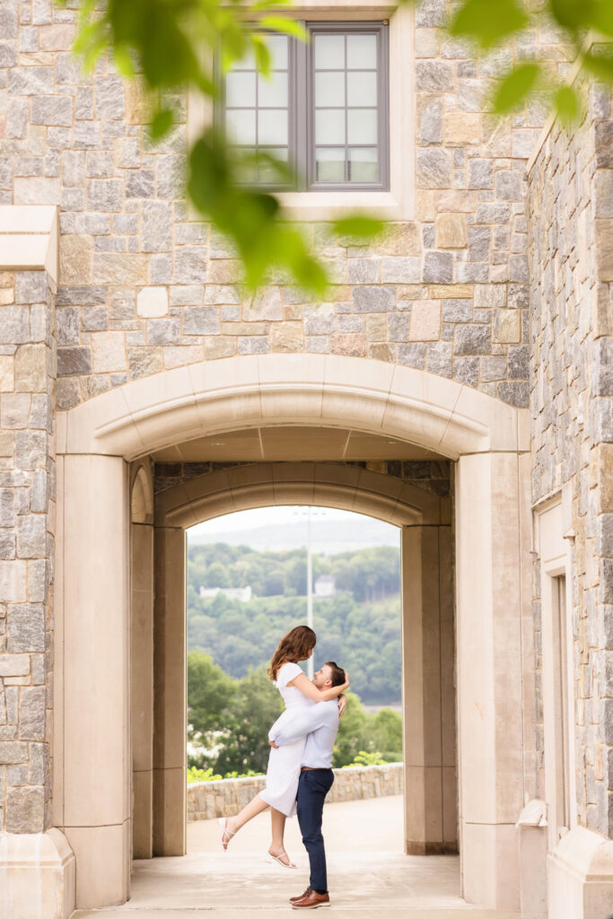 Couple framed by stone arch with distant Hudson River view