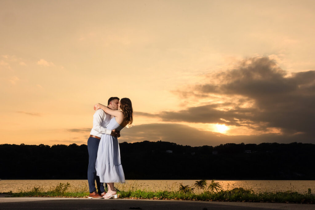 Couple embracing with dramatic sunset behind them