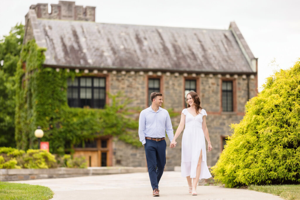 Couple walking hand-in-hand by ivy-covered buildings