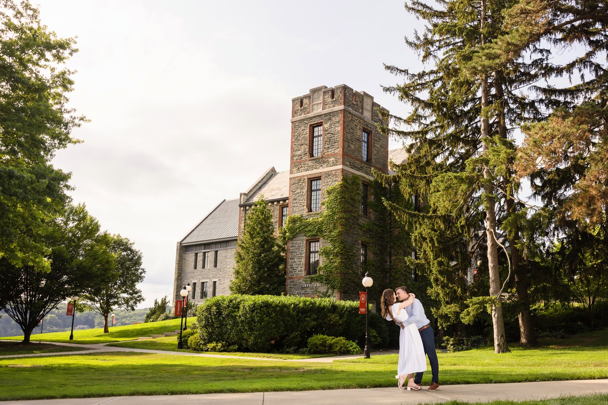 Couple holding hands in front of Marist’s historic stone tower