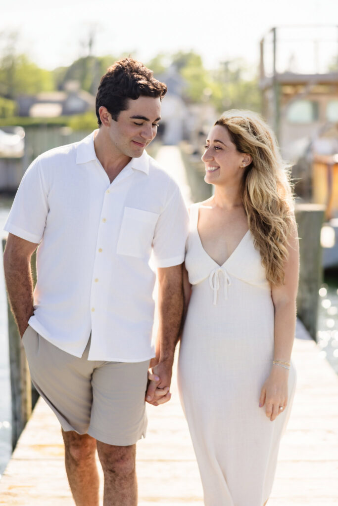 The couple walking along a sunny dock in Greenport, radiating joy and ease.