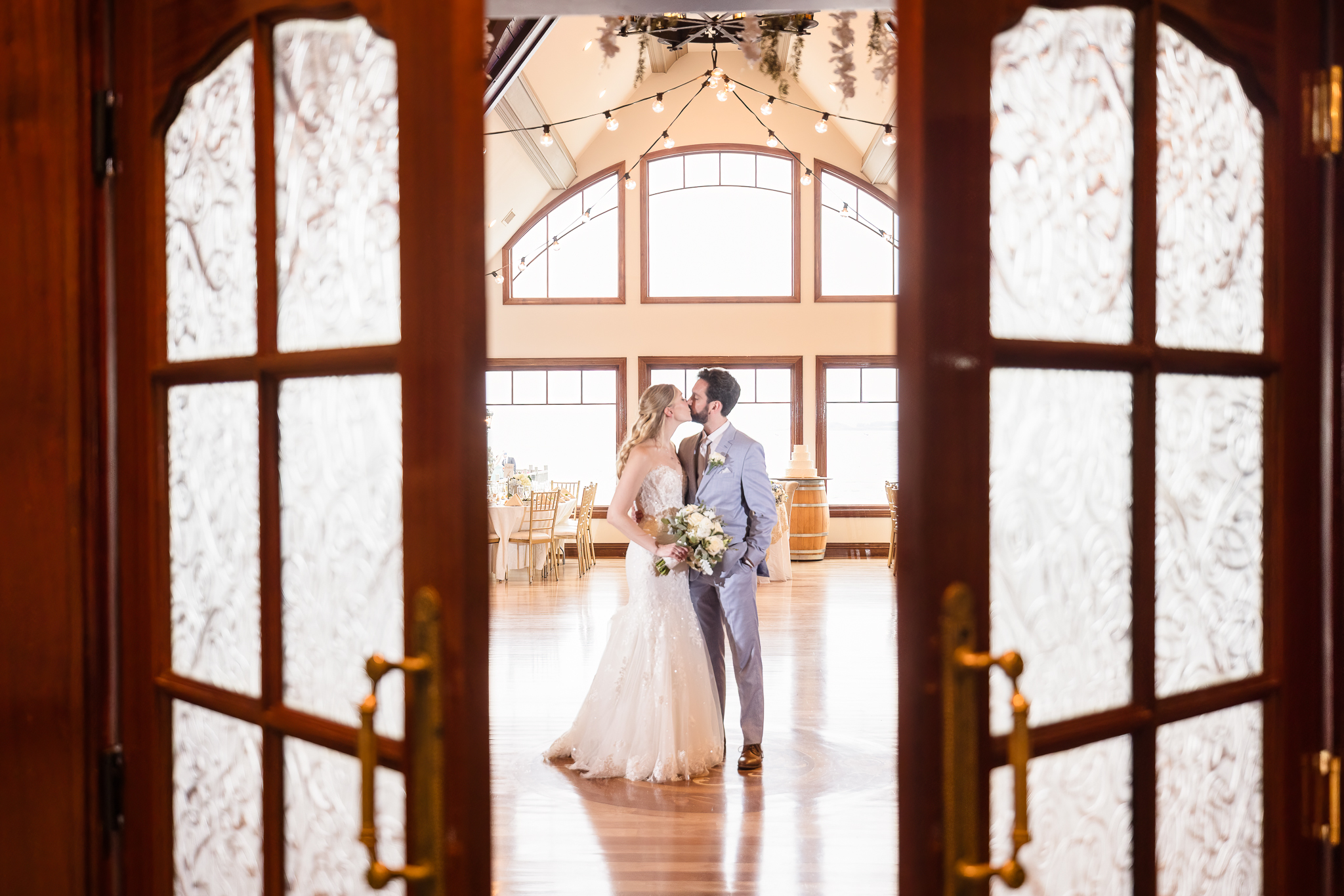 Bride and groom share a quiet moment framed by the grand wooden doors of Riviera Waterfront Mansion.