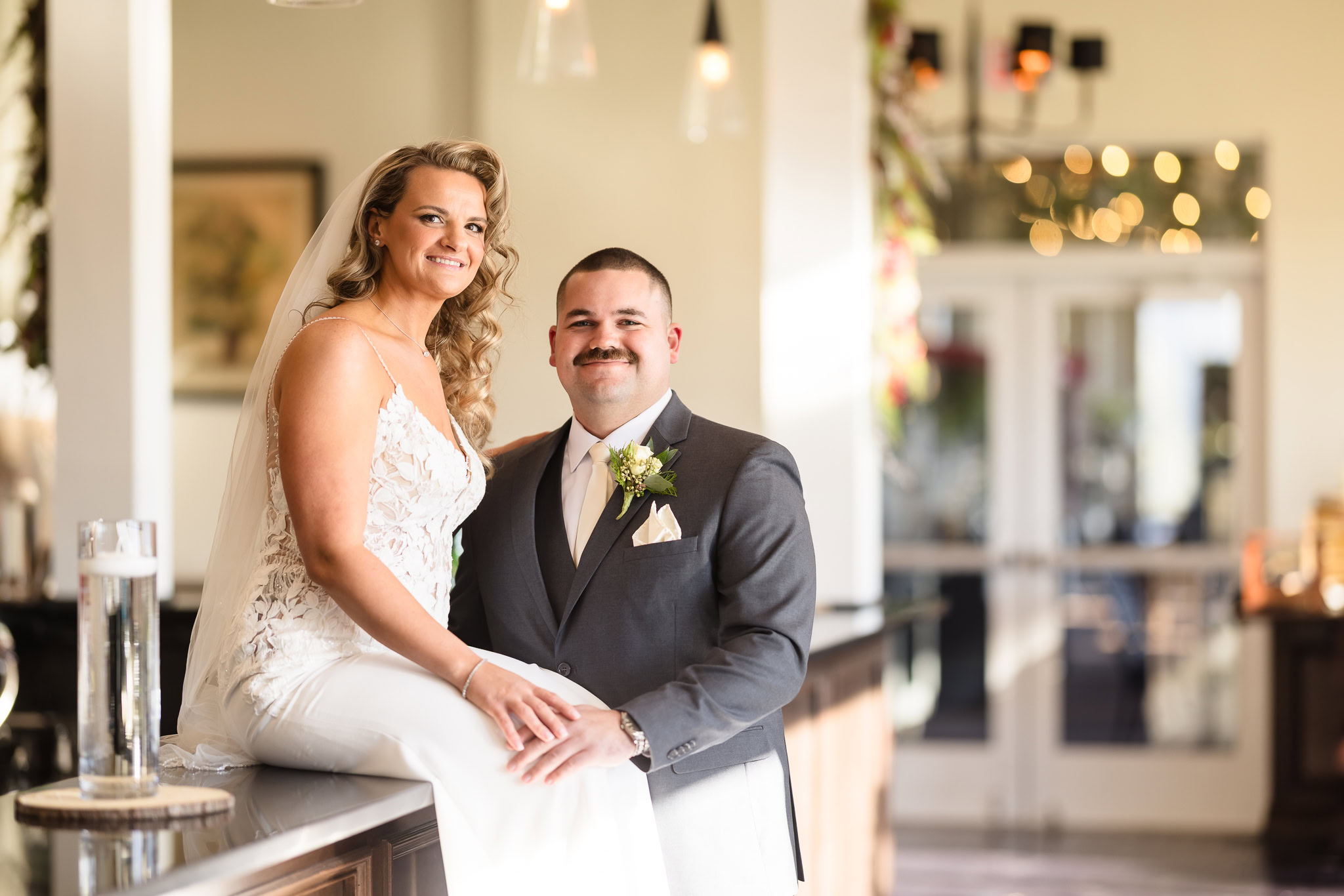 Bride and groom pose together in the softly lit lounge at Stonebridge Country Club, surrounded by warm natural light and elegant modern decor.