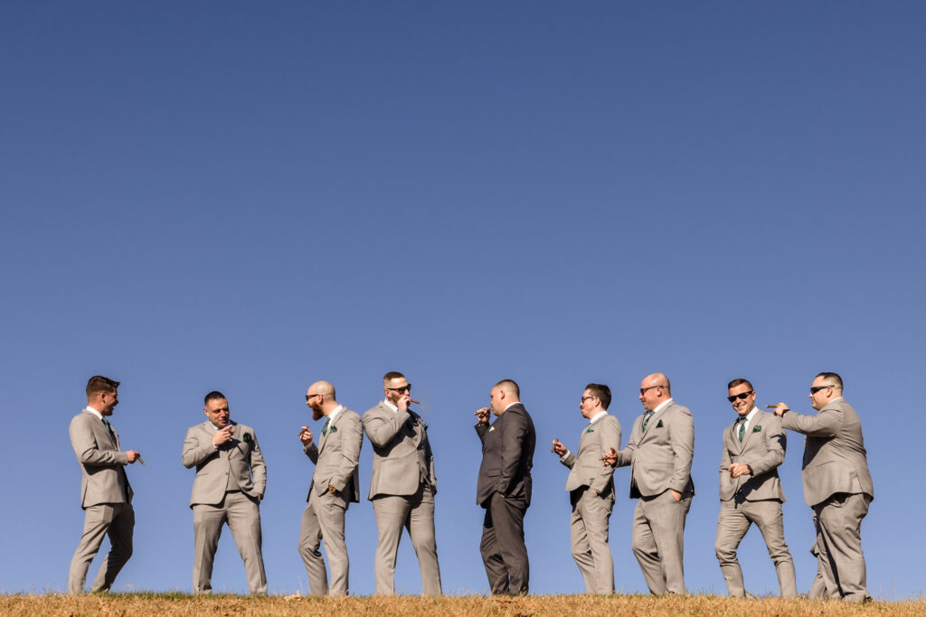 Groom and groomsmen walk in formation along the hilltop at Stonebridge Country Club, framed by a vivid blue sky and golden hour light.