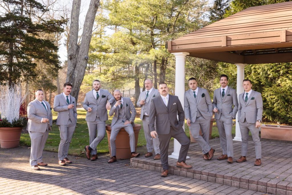 Groom and groomsmen walk together in front of the gazebo at Stonebridge Country Club, enjoying a relaxed and lighthearted pre-ceremony moment.

