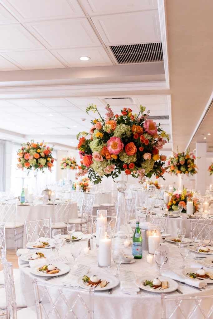 Elegant reception ballroom at Watermill Caterers featuring tall floral centerpieces, candlelight, and beautifully set guest tables.