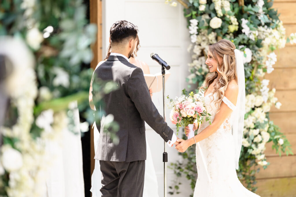 Bride and groom exchanging vows at outdoor ceremony