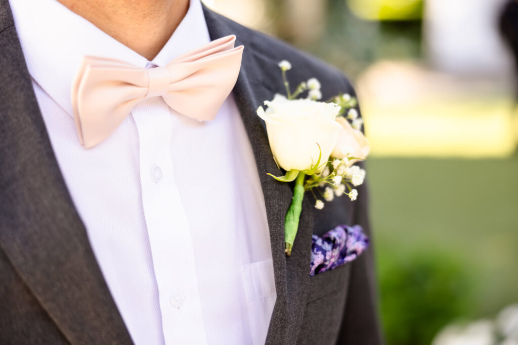 Close-up of groom’s blush bowtie and boutonniere