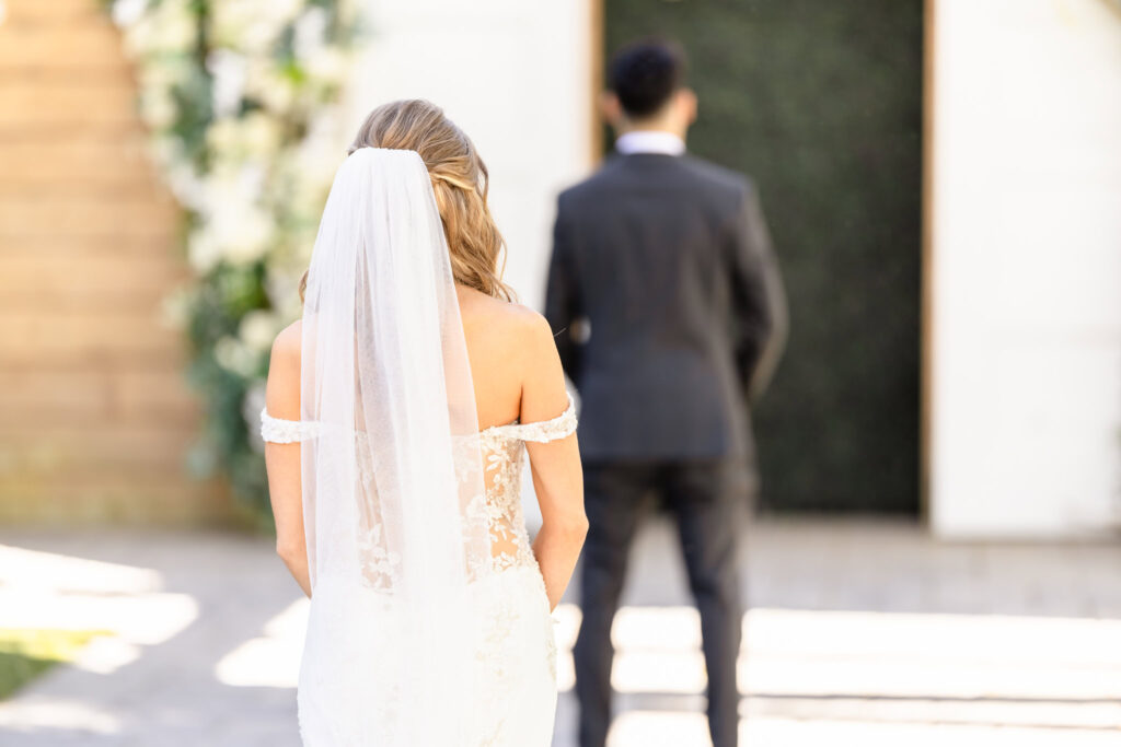 Bride standing behind the groom just before the first look