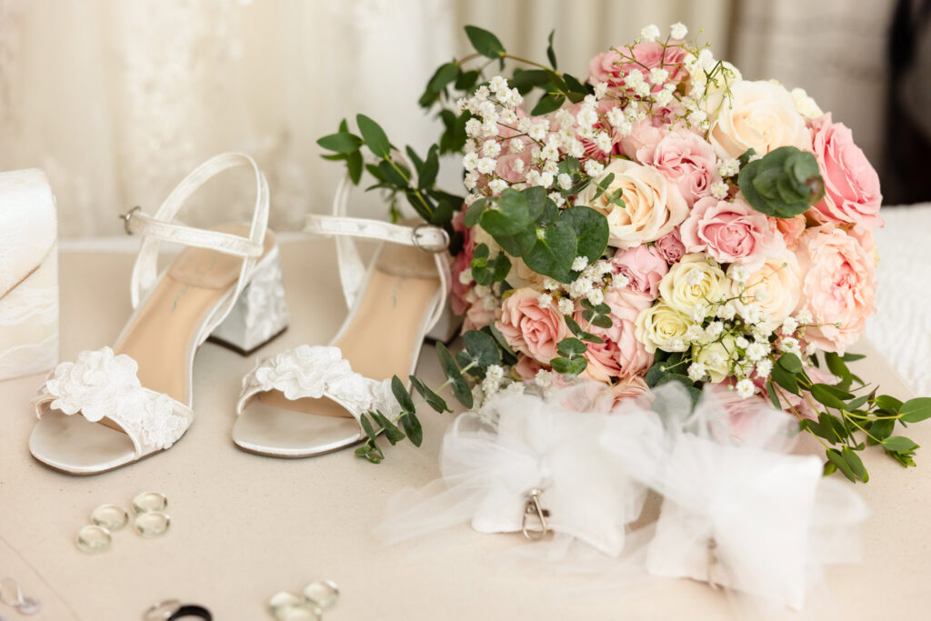 Elegant bridal details with ivory heels, heirloom jewelry, and a blush bouquet at the Watermill.