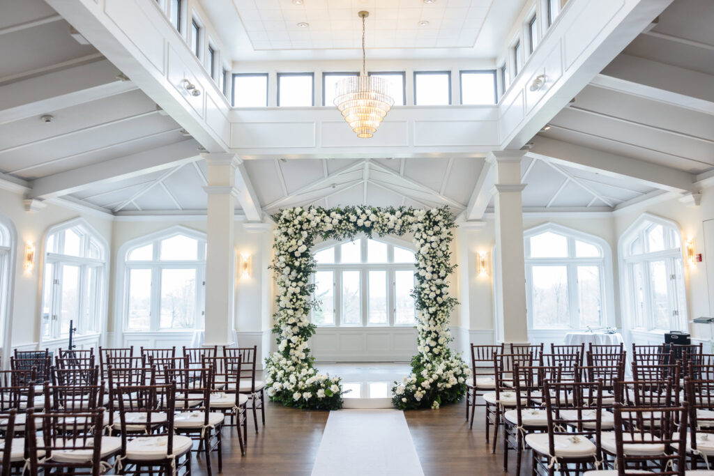 Sunlit indoor ceremony space at Whitby Castle with white florals and large windows
