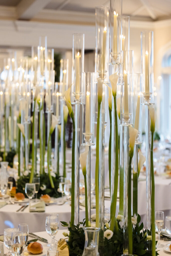 Reception table decor featuring tall floral arrangements and candlelight at Whitby Castle