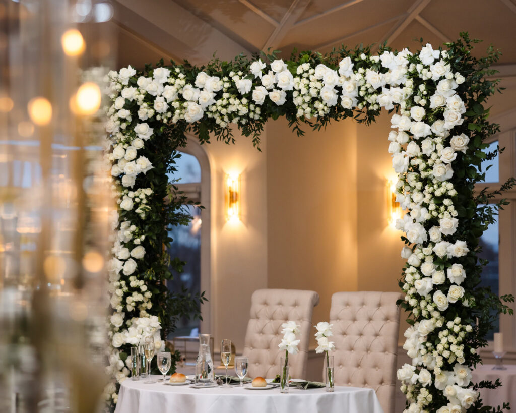 Intimate sweetheart table with white floral arch inside Whitby Castle