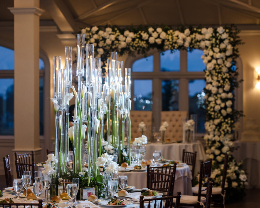 Luxurious reception setup at Whitby Castle with tall centerpieces and floral arch