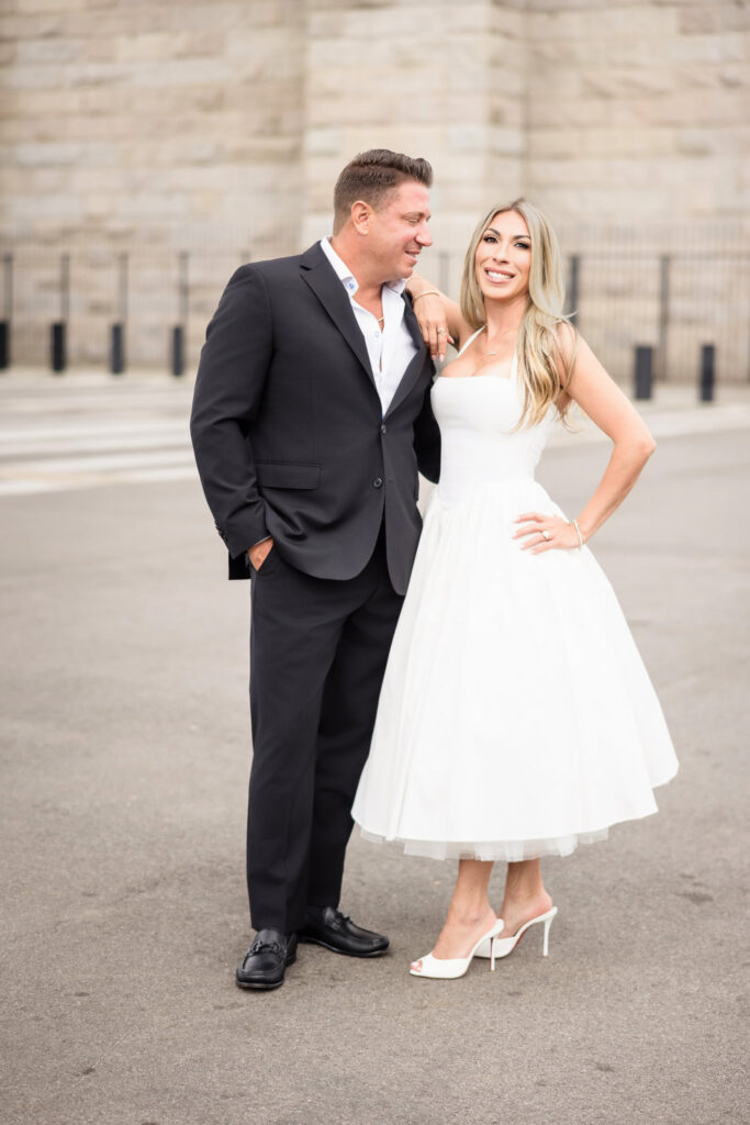 Engaged couple standing together on a city street in DUMBO, Brooklyn, during their summer photo session.