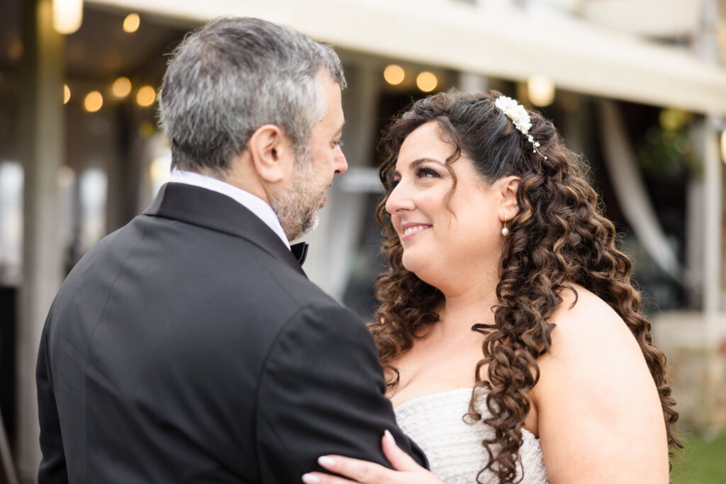 Bride and groom sharing a close smile during their ceremony, with emotion and connection shining in their eyes.
