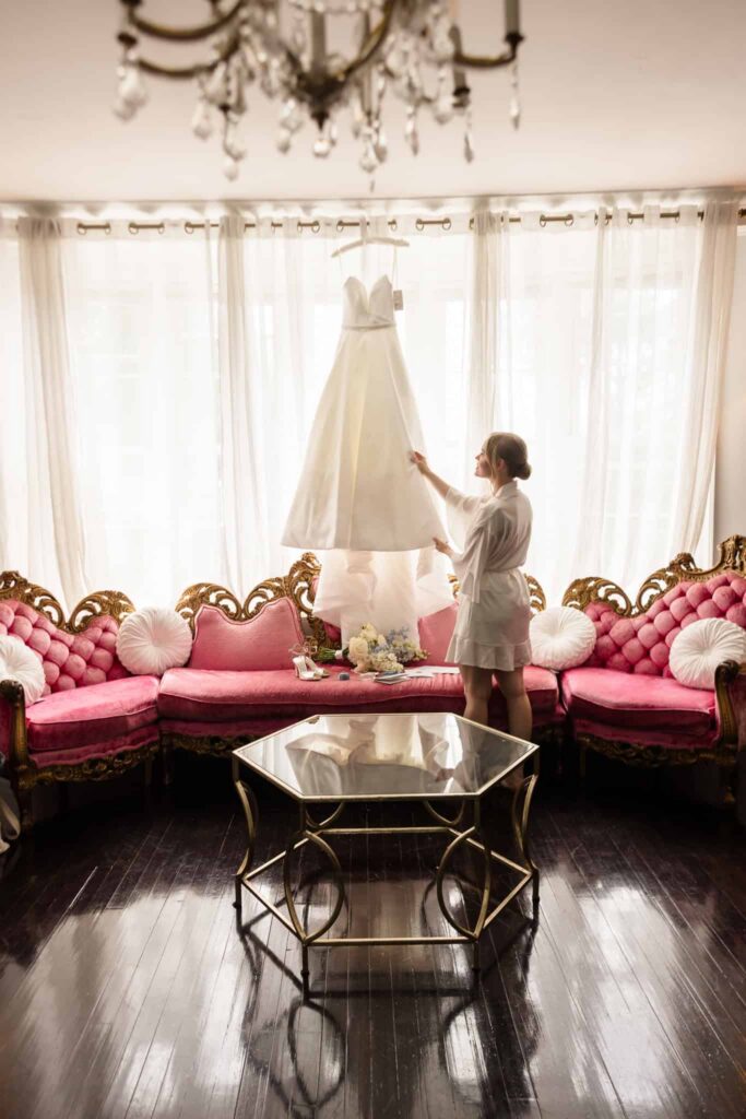 Bride admiring her wedding dress inside the elegant bridal suite at Watermill Caterers.