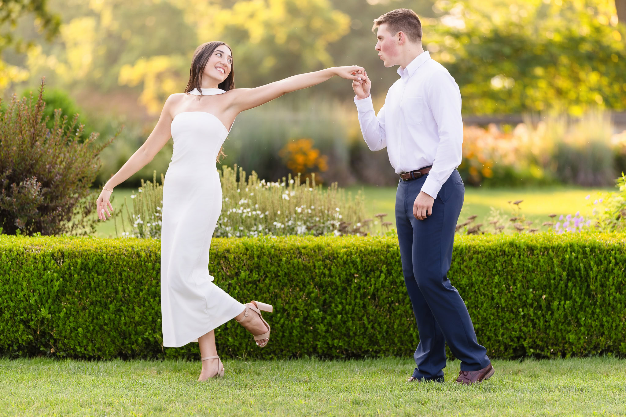 Bride-to-be playfully twirling in front of her fiancé, who holds her hand like a classic dance move.