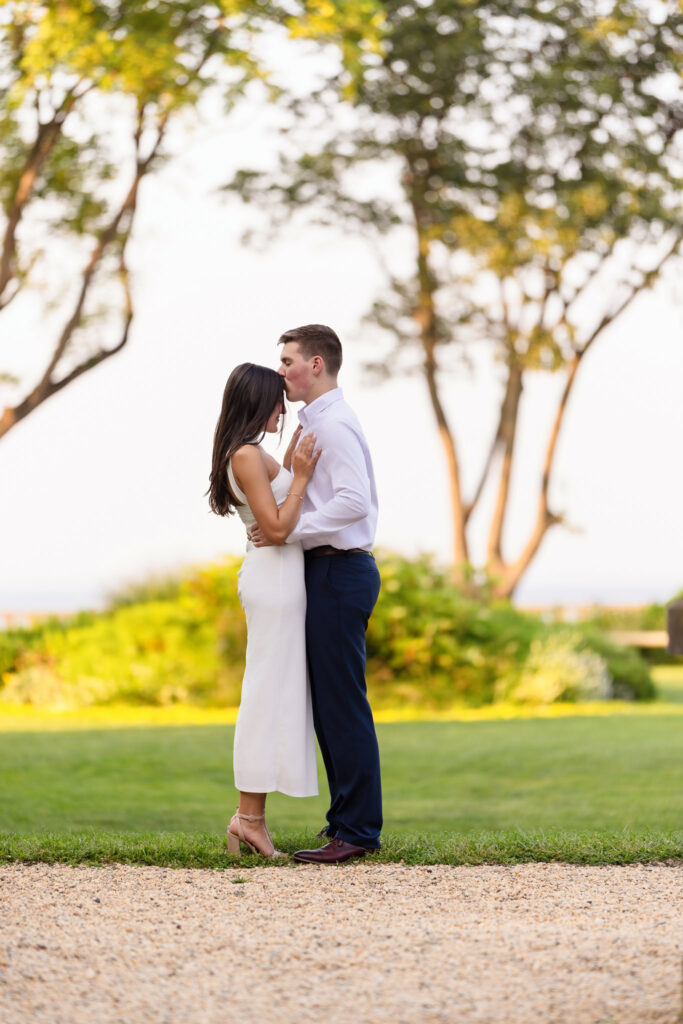 Groom-to-be kissing his fiancée’s forehead in a quiet, emotional moment in the garden.