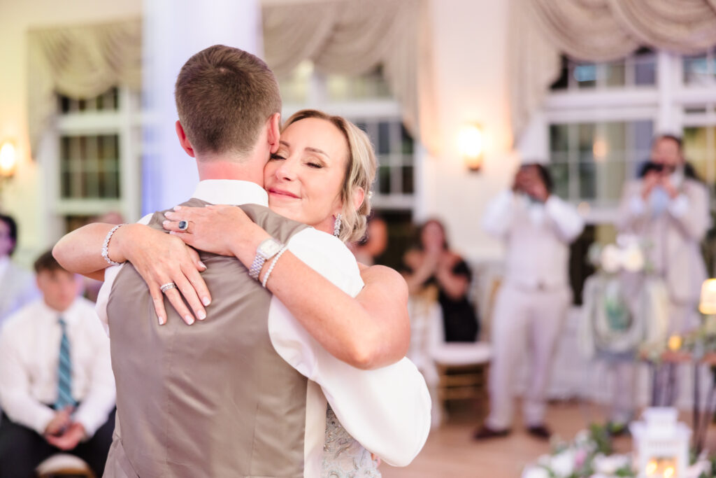 Groom sharing an emotional dance with his mother during the wedding reception at Camp Pa-Qua-Tuck.
