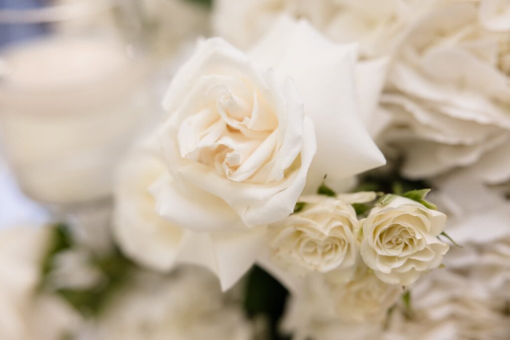 Close-up of white roses in an elegant floral arrangement at a St. Regis New York wedding reception, symbolizing timeless luxury and romance.