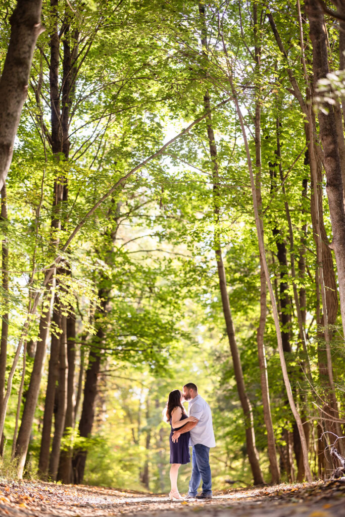 Couple kissing in the woods at their Croton Gorge Park Engagement session. 