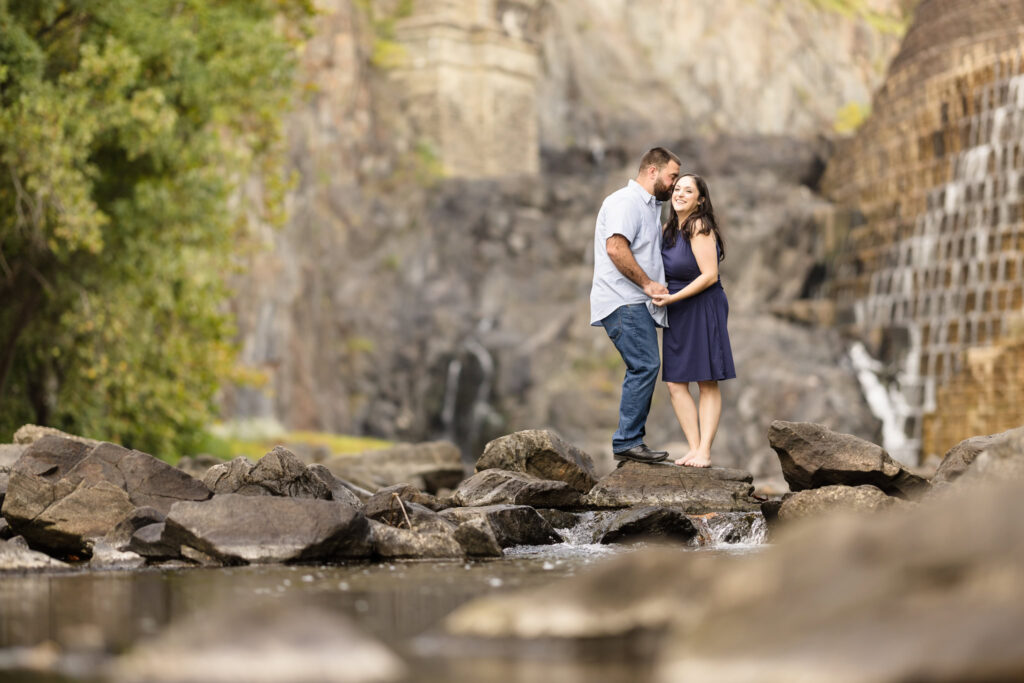 Couple standing on rocks in a river at Croton Gorge Park. 